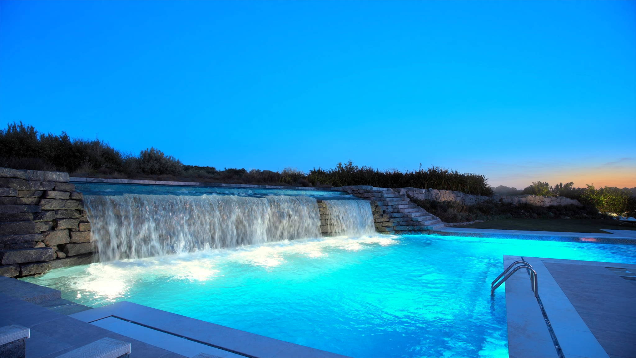 Waterfall cascading into a freshly resurfaced pool
